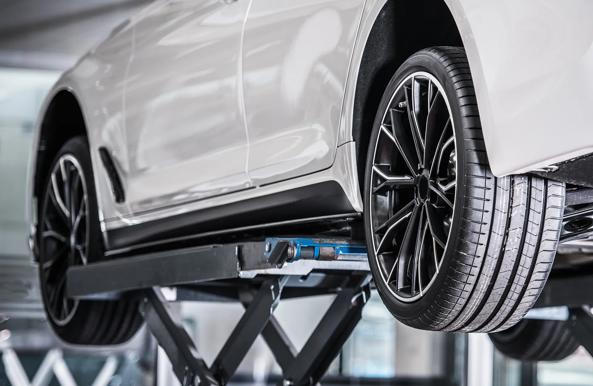 Weißes Auto in einer Kfz Werkstatt auf der Hebebühne