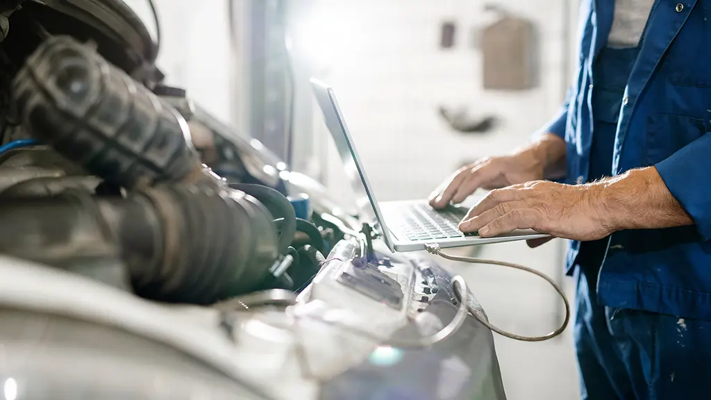 Kfz Mechaniker checkt die Elektrik